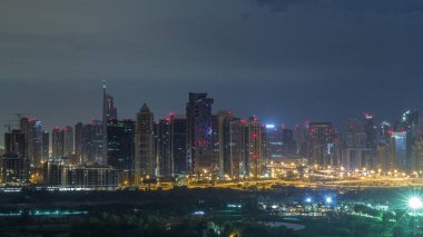 Jumeirah göl kuleleri ve Dubai marina yanıp sönen ışıklar, Dubai, Birleşik Arap Emirlikleri ile tüm gece zaman aşımı sırasında gökdelenler ve golf sahası aydınlatılmış. Yeşiller bölgesinden havadan görünüm