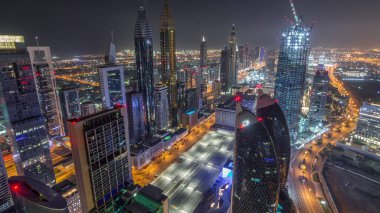 Dubai, BAE 'deki tüm gece boyunca Sheikh Zayed Yolu ve DIFC yakınlarındaki binaların panoramik silueti. Finansal merkezde ve şehir merkezinde aydınlık gökdelenler ve modern kuleler