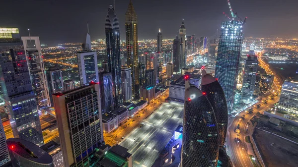 Dubai, BAE 'deki tüm gece boyunca Sheikh Zayed Yolu ve DIFC yakınlarındaki binaların panoramik silueti. Finansal merkezde ve şehir merkezinde aydınlık gökdelenler ve modern kuleler