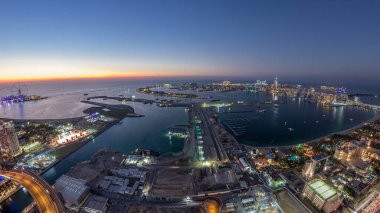 Palm Jumeirah Adası gün gece geçiş timelapse için hava gün batımı manzarası. Üstten görünüm ışıklı Villaları, otelleri ve yatlar ile akşam. Yeni cruise terminal inşaat süreci