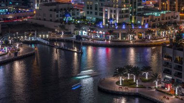 Geçen tekneler ve avuç içi gün gece ile promenade ile lüks Dubai Yat Limanı kanal timelapse geçiş, yukarıdan bakışta akşam güneş battıktan sonra Top. Dubai, Birleşik Arap Emirlikleri