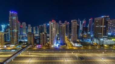 Dubai Yat Limanı timelapse tüm gece boyunca muhteşem çatı manzarası. Işıklandırılmış gökdelenler, Birleşik Arap Emirlikleri, dönüm büyük bir şehir. Hava Jlt görünümünden