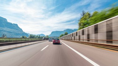 Dağlar ve çayırlar İtalya timelapse hyperlapse drivelapse içinde bir otoyolda sürüş. Elektrik direkleri, güzel manzara ve mavi gökyüzü ile beyaz bulutlar. Yüksek hız