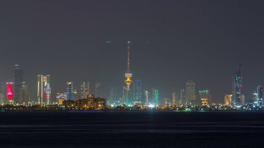 Kuveyt şehir merkezindeki gökdelenler ile gece gündüz geçiş zamanları alacakaranlıkta aydınlandı. Kuveyt Şehri, Orta Doğu. Suyu yansıtan bilimsel merkezden görünüm