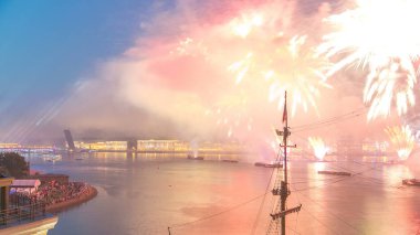 Kızıl Yelkenliler Festivali sırasında Rusya 'nın St. Petersburg üzerinde havai fişeklerin uçuş zamanı. Üçlemeci Köprüsü ve rıhtımın olduğu bir çatıdan vurulmuş. Ay yükseliyor.