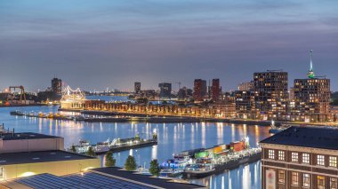 Rotterdam, Hollanda 'daki Katendrecht Yarımadası ve Maashaven Limanı' nın panoramik hava ve gece geçiş zamanı. Şehir silueti modern gökdelenler ve geleneksel Hollanda rıhtım evleri