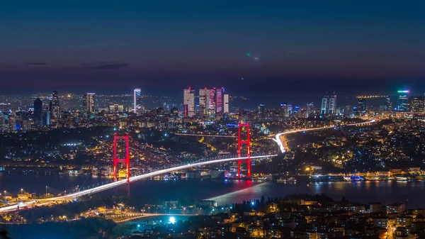 İstanbul kenti, Camlica Tepesi 'ndeki Bosphorus Köprüsü' nün (15 Temmuz Şehitleri) ve finans merkezinin havadan görünüşü günden geceye ufuk çizgisine bakıyor. Köprüde trafik ve Boğaz 'da gemi.
