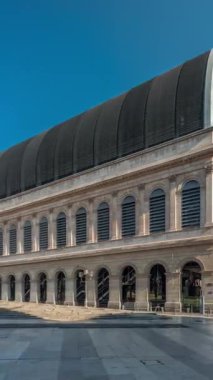 Modern cam kubbe ile birleştirilmiş neoklasik mimari içeren Lyons opera binasının hiperlapesi. Mavi gökyüzünün altında heykelleri olan tarihi ve turistik bir yer. Yan görünüm zaman dilimi