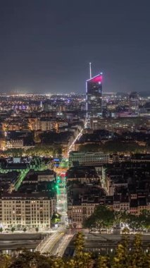 Geceleri Fourviere Hill 'den gökdelenlerle Lyon' un panoramik hava manzarası. Ufuk çizgisinde Rhone Nehri ve ikonik kent simgeleri yer alıyor. Evler çatılar ve caddelerde trafik