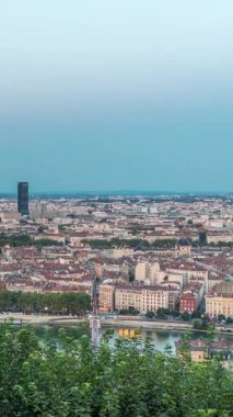 Gün batımından sonra Lyon 'un panoramik hava görüntüsü Fourviere Hill' den gece dönüşümüne kadar. Ufuk çizgisinde Rhone Nehri ve sıcak bir akşamda aydınlanan ikonik kent simgeleri yer alıyor.