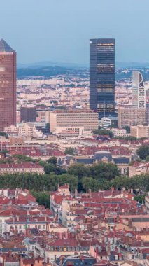 Gün batımından sonra Lyon 'un panoramik hava görüntüsü Fourviere Hill' den gece dönüşümüne kadar. Gökdelenler gökdelenlerle çevrili ve sıcak bir akşamda aydınlanan ikonik şehir simgeleri yer alıyor.