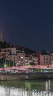 Aziz George Kilisesi, Quais de Saone ve Fourviere Bazilikası 'nın Fransa' nın Vieux Lyon kentindeki bir yaya köprüsünden hızlandırılmış zaman aşımına uğraması, geceleri tarihi mimari, yansımalar ve manzaralı nehir manzarası sergilenmektedir.