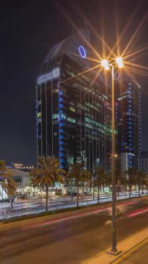 Suudi Arabistan, Riyad 'ın şehir manzarası gece zaman çizelgesi. Işıklı kulelerin, gökdelenlerin, King Fahd Yolu 'nun ve yoğun trafiğin panoramik görüntüsü. Palmiyeler ve sokak lambaları şehrin içinden geçen ana otoyolda.