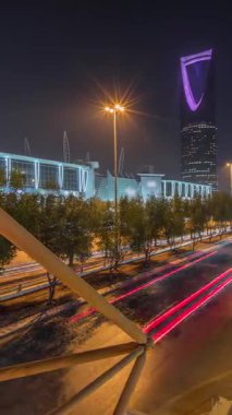 Riyad 'ın panoramik gece zaman çizelgesine göre karayolu trafiği var. Aydınlatılmış modern binalar canlı manzaranın etrafını sarar. Krallık Kulesi Suudi Arabistan 'ın başkentinin en yüksek gökdelenidir..