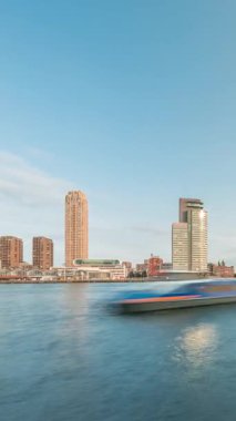 Panorama, Nieuwe Maas River bankasından Wilhelminapier ve Kop van Zuid 'e kadar olan zaman çizelgesini gösteriyor. Modern gökdelenler, feribot istasyonu ve Erasmus Köprüsü, kıyıdan geçen tekneler.