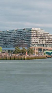 Rotterdam şehir merkezindeki Hotel New York tarihi cepheli modern binaların zaman çizelgesi. Eski Hollanda-Amerika Hat Karargahı. Tekneler geçerken insanlar rıhtımda dinleniyor. Simgesel mimari