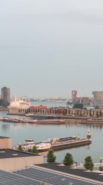 Güneş doğduktan sonra Maashaven 'da Katendrecht ve Maas Nehri' nin iç kısımlarına demirlemiş gemileriyle birlikte havadan izleniyor. Eski fabrika ofis ve etkinlik alanına dönüştü. Rotterdam, Hollanda