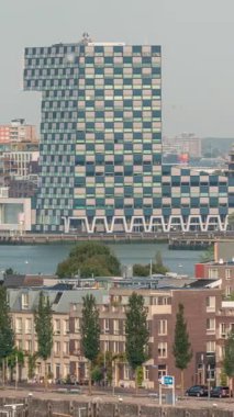 Rotterdam, Hollanda 'daki Katendrecht Yarımadası ve Maashaven Limanı' nın panoramik zaman çizelgesi. Şehir sabahları gökdelenler, vinçler ve geleneksel Hollanda rıhtım evleri.
