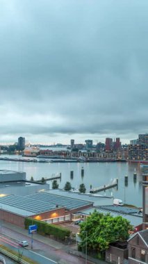 Rotterdam 'daki Katendrecht ve Maas Nehri' nin dramatik gökyüzü, Maashaven 'ın gündüz ve gece arası panoramik görüntüsü. Eski fabrika yakınlarındaki trafik ofis ve etkinlik alanına dönüştü