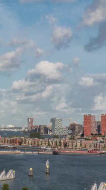 Arka planda Katendrecht ve Maas Nehri 'nin yer aldığı Maashaven' ın havadan görüntüsü. Sıcak sabah ışığıyla gökdelenlerin üzerinde dramatik bulutlu bir gökyüzü. Arkaplanda kargo portu