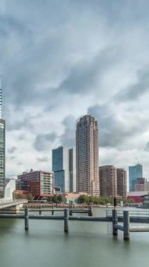 Hollanda, Rotterdam 'da bulunan ve yerel olarak Hoerenloper olarak bilinen Rijnhaven Köprüsü' nden Hiperlapse. Arka planda modern gökdelenleri ve bulutlu gökyüzü olan bir yaya ve bisiklet köprüsü