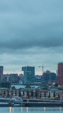Rotterdam, Hollanda 'daki Katendrecht Yarımadası ve Maashaven Limanı' nın panoramik hava ve gece geçiş zamanı. Şehir silueti modern gökdelenler ve geleneksel Hollanda rıhtım evleri