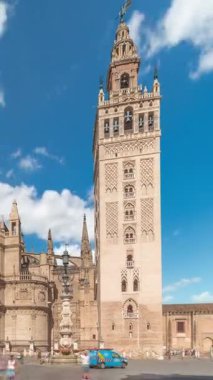 Seville Katedrali ve Giralda Kulesi Sevilla, İspanya 'da zaman atlaması. Dünyanın en büyük gotik katedrali olan UNESCO miras alanı Virgen de los Reyes Meydanı 'nda mavi gökyüzünün altında yer almaktadır.