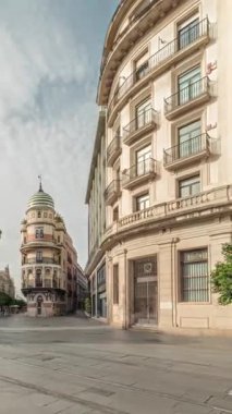 Avda boyunca yürüyen yayalar. De la Constitucion, Seville, İspanya 'nın Casco Antiguo bölgesindeki ana cadde. Edificio de la Adriatica ile zaman atlaması, tarihi binalar ve geçen tramvaylar