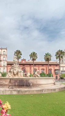 Sevilla 'daki Hispalis Çeşmesi, en güzel çeşmelerden biri, renkli çiçekler ve tarihi binalarla çevrili. Arka planda bulutlu bir gökyüzü ile hızlandırılmış zaman çizelgesi.