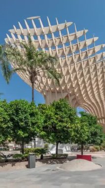 Encarnacion Meydanı 'ndaki Metropol Şemsiyesi hiperlapası, panoramik yürüyüş yolu ve arkeoloji müzesi olan fütürist bir ahşap yapı. Mavi gökyüzü, ağaçlar ve şehir manzarası Sevilla, İspanya.