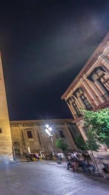 La Giralda ve Seville Katedrali geceleri aşırı hızlanarak altın ışıklarla parıldıyor. Tarihi çan kulesi, gotik detaylar ve aydınlatılmış sokaklar Sevilla, İspanya 'da büyülü bir atmosfer yaratıyor.