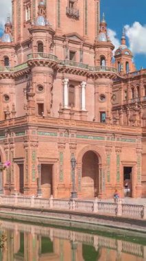 Seville Timelapse 'deki Plaza de Espana, Ibero-American Exposition için inşa edilen Maria Luisa Park' taki büyük bir mimari kompleks. Mavi bulutlu gökyüzünün altında kemerler, kanallar ve kırmızı duvarlar.