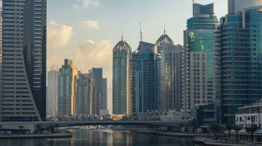 Dubai Marina Kanalı 'nın sabah manzarası, modern kuleleri ve yatlarıyla Dubai' deki köprüden yansıyan güneş doğumu saati, Birleşik Arap Emirlikleri.