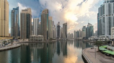 Dubai Marina Kanalı, modern kuleleri ve yatları olan liman kenti Dubai 'deki köprüden gece gündüz geçiş zamanı olan Birleşik Arap Emirlikleri' ne yansıyor. Güneş doğmadan önce etraftaki gökdelenler