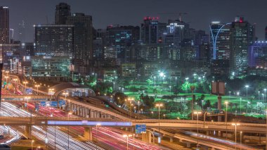 Dubai Golf Sahası 'nın arka plan hava gününden geceye geçiş zamanlarında yeşillik ve tekom bölgelerinden oluşan bir manzarası var. Şeyh zayed yolunda metro istasyonuyla trafik vardı.