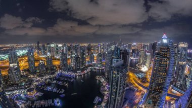 Dubai Marina gökdelenleri ve Jumeirah göl kuleleri Birleşik Arap Emirlikleri 'nde hava gününden gece geçiş zamanına kadar panoramik manzara. Yolda trafik vardı.