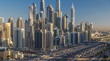 Dubai Yat Limanı gökdelenler hava üstten görünüm Jlt üzerinden sabah Dubai timelapse, BAE güneş doğarken sırasında. Modern kule uzun gölgeler aşağıya taşınması ve Şeyh zayed yolu üzerinde trafik ile.