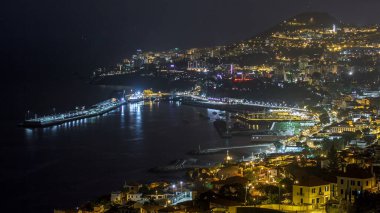 Gün batımından sonra adanın manzarası Funchal 'dan gece dönüşümüne, Madeira' ya, Portekiz zamanına. Limanda akşam aydınlatmasıyla