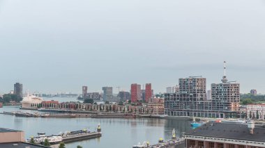 Güneş doğmadan önce Maashaven 'daki kuleler üzerindeki hava manzarası demirli gemilerle, Katendrecht ve Maas Nehri' yle, Rotterdam 'la geçiş zamanlarını gösteriyor. Aydınlatılmış fabrika ofis ve olay alanına dönüştürüldü