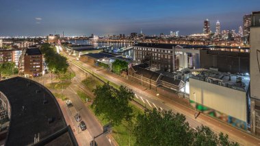 Rotterdam 'daki Katendrecht ve Maas Nehri gibi demirli gemilerle Maashaven' daki hava panoramik görüntüsü günden geceye geçiş zamanı. Eski fabrika yakınlarındaki trafik ofis ve etkinlik alanına dönüştü