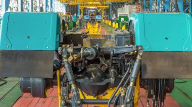 Konveyör montajı, traktörün gövdesini büyük endüstriyel fabrika zaman diliminde sahneleyecek. Çerçeve montajı, çamurluk kurulumu ve montajlanan diğer parçalar