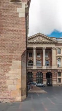 Rönesans zindanı ve Capitole arka tarafındaki klasik tuğla cephesi zaman atlaması, Fransa 'nın Toulouse belediyesi, Charles de Gaulle Meydanı' nda bulutlu bir gökyüzünün altında ağaçlarla çevrili.