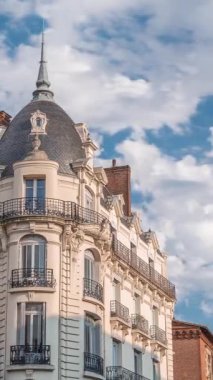 Fransa 'nın Toulouse şehrinde Rue du Languedoc ve Theodore Ozenne kavşağındaki tarihi cephelerde. Mağazalar, Carmes metro istasyonu yakınlarındaki kafeler canlı şehir merkezinde bulutların altında mavi bir gökyüzünde