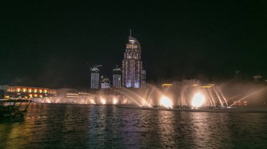 Dubai 'nin Dans Çeşmesi ve Göl' den Geceye Zaman Kaynağı, seçilen müziğin ritmine Dubai, BAE 'de eşlik eder. Çeşme alışveriş merkezi ve oteller tarafından gözden kaçırılmış.