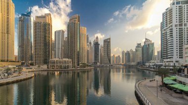 Dubai Marina Kanalı, modern kuleleri ve yatları olan liman kenti Dubai 'deki köprüden gece gündüz geçiş zamanı olan Birleşik Arap Emirlikleri' ne yansıyor. Güneş doğmadan önce etraftaki gökdelenler