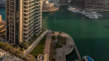 Modern gökdelenler ile Yatlar Dubai, Birleşik Arap Emirlikleri Dubai Marina gündoğumu ışıklar timelapse parlayan bir bakış. Camına yansıyan ışık ışınları.
