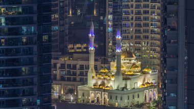 Al Raheem Camii gökdelenler gün gece geçiş timelapse Marina arasında yürümek içinde Dubai Marina, Dubai, Uae. Akşam güneş battıktan sonra hava üstten görünüm