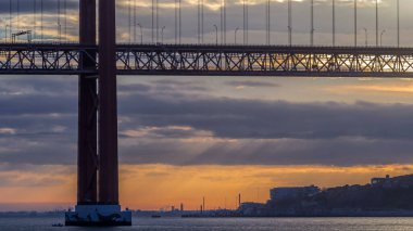 Lisbon city sunrise with April 25 bridge timelapse close up view, River and waterfront early morning. Purple clouds