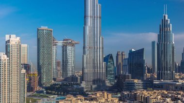 Dubai Şehir Merkezi 'nin ufuk çizgisi, güneş doğarken Burj Halife ve Dubai' deki diğer panoramik kulelerle birleşik Arap Emirlikleri. Gökdelenin cam yüzeyinden yansıyan güneş