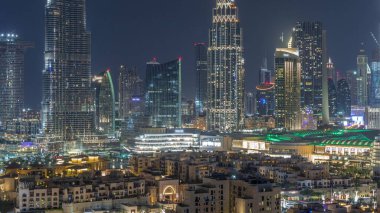 Dubai Şehir Merkezi 'nin ufuk çizgisi gün batımından gece saatlerine kadar Dubai, Birleşik Arap Emirlikleri' nin tepesinden panoramik manzaralı kulelerle dolu. Güneş gökdelenden yansıyor. Çember yollarda ve çeşmelerde trafik